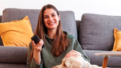 Una chica feliz sujeta el mando de la televisión