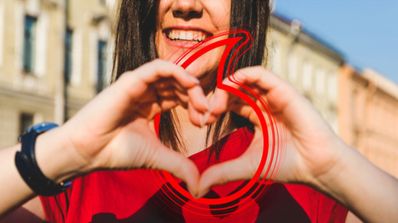 Una chica haciendo la forma del corazón con las manos y el logo de Vodafone