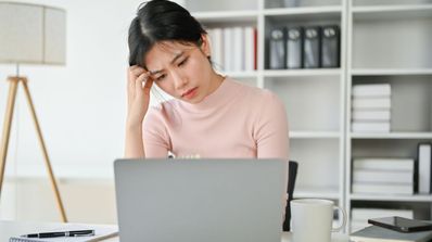 Una chica preocupada mirando su ordenador portátil