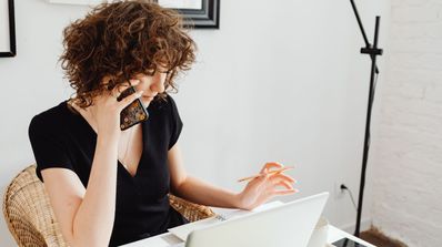 Una chica en la oficina trabajando y hablando por teléfono
