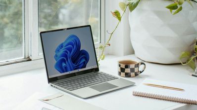 Un portátil con Windows 11 al lado de una ventana