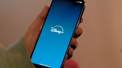 Sujetando un teléfono móvil con el logo de Disney+