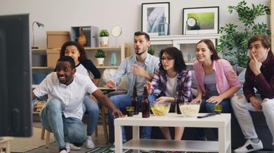 Un grupo de amigos viendo deportes con emoción
