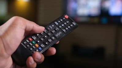 Buscando canal con el mando a distancia en la televisión