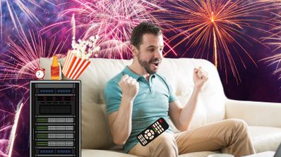 Un hombre feliz sentado en el sofá rodeado de fuegos artificiales