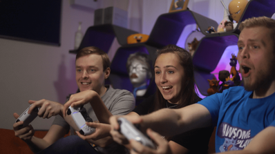 Tres jugadores utilizando mandos DualSense blancos de PlayStation 5 durante una partida multijugador.