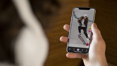 Logo de TikTok sobre un fondo de colores neón, representando la creatividad en la creación de vídeos con fotos