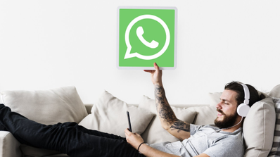 Un hombre tumbado viendo notificaciones de WhatsApp en su móvil