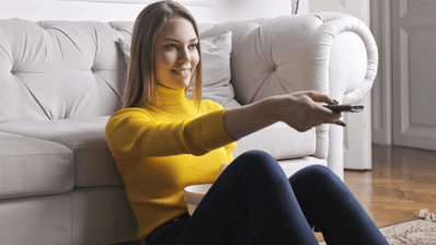 Chica viendo la televisión cambiando de canal
