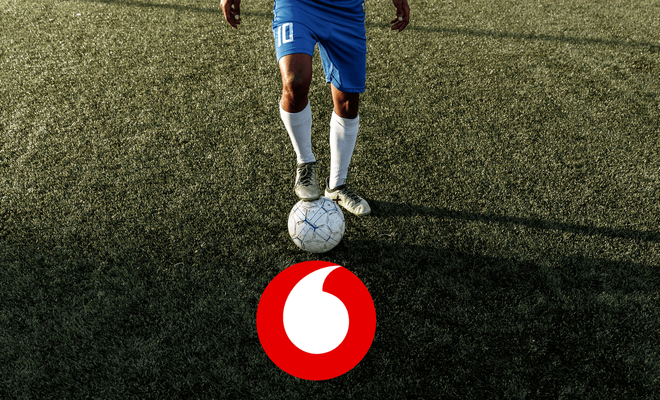 Pies de un futbolista profesional controlando un balón junto al logo de Vodafone, ilustrando la oferta de fútbol para bares y restaurantes