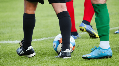 Varias piernas de jugadores de fútbol en el campo