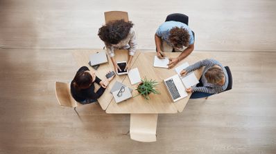 Equipo multicultural de Recursos Humanos analizando métricas de rendimiento de talento en pantallas digitales con la interfaz de la plataforma de IA Orbio