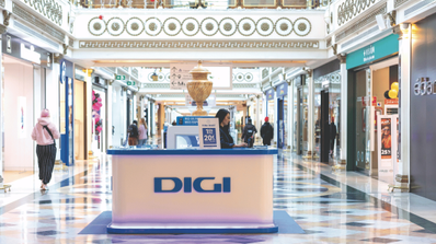 Fachada de una tienda física de Digi en un centro comercial de Madrid, con su logotipo rojo y ofertas de fibra óptica y móvil en el escaparate