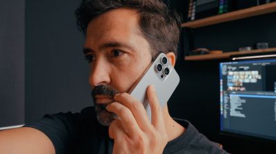 Hombre comparando tarifas familiares de fibra y móvil en su ordenador portátil mientras sonríe