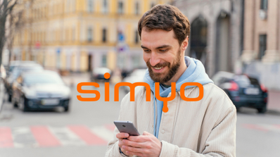 Cliente de Simyo sonriendo mientras consulta en su smartphone la promoción de 100 GB de datos gratis por Navidad