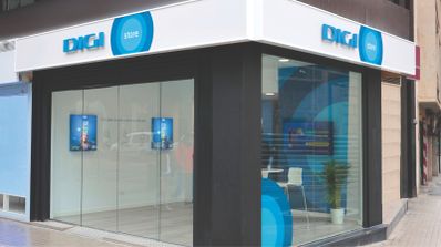 Fachada de una tienda física de Digi en una calle de España, con su logotipo rojo corporativo y cristalera principal.