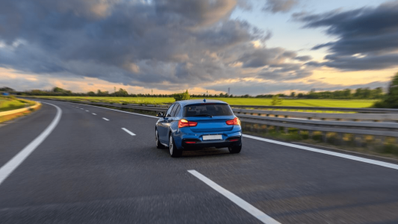 Un coche circulando por la carretera por el carril derecho, aplicando las leyes de Tráfico