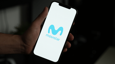 Sujetando un móvil con el logo de Movistar.