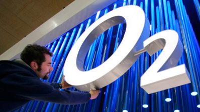 Logotipo de O2 España sobre fondo azul, acompañado de iconos que representan fibra óptica, señal móvil 5G y un televisor, ilustrando la actualización de sus tarifas convergentes.