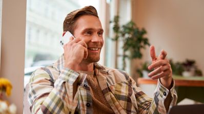 Smartphone mostrando una llamada entrante de un número desconocido, con iconos de alerta de posible spam, ilustrando el momento de decidir si contestar.