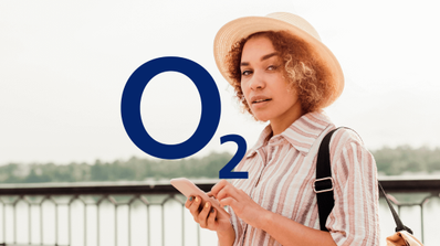Viajero consultando su smartphone en un aeropuerto, ilustrando el uso de datos móviles en roaming con O2