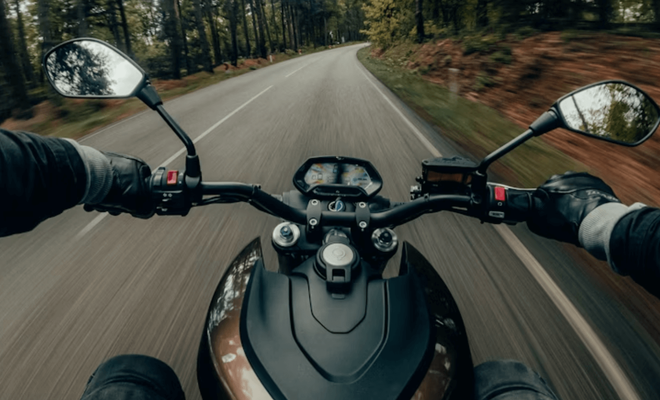 Vista en primera persona desde el casco de un motorista circulando por una carretera de curvas, mostrando la importancia de una visión periférica clara