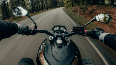 Vista en primera persona desde el casco de un motorista circulando por una carretera de curvas, mostrando la importancia de una visión periférica clara
