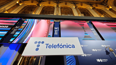 Stand promocional de Telefónica en un evento de telecomunicaciones, con el logo de Movistar y pantallas mostrando servicios de fibra óptica