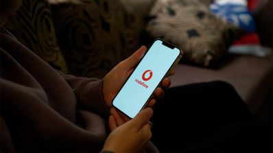 Smartphone mostrando el logo de Vodafone y un icono de señal 5G, ilustrando la conexión de alta velocidad de la tarifa móvil ilimitada