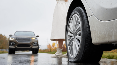 Imagen de una mujer que ha pinchado la rueda en carretera