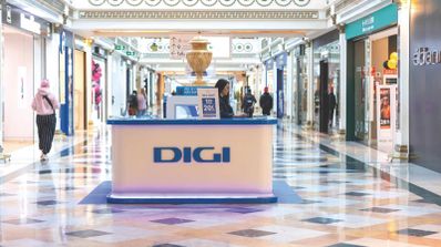 Mostrador de atención al cliente en una tienda oficial de Digi en España, con pantallas promocionando sus servicios de fibra y televisión