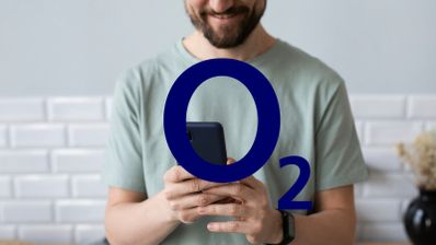 Hombre consultando la tienda online de O2 en su smartphone para renovar su terminal, con el logo de la compañía visible en la pantalla.