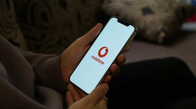 Smartphone mostrando el logo de Vodafone y una gráfica de consumo de datos ilimitados en una pantalla con fondo azul corporativo.