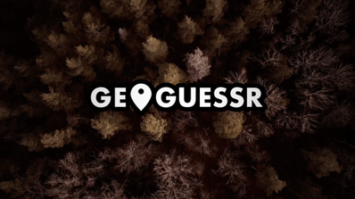 Pantalla de inicio del modo SpookyGuessr de GeoGuessr, mostrando una carretera rural de noche con niebla y una figura siniestra al fondo