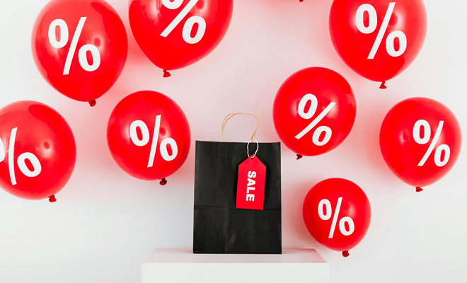 Bolsa de la compra con globos negros que anuncian las rebajas del Black Friday, ilustrando el concepto de las compras de final de año