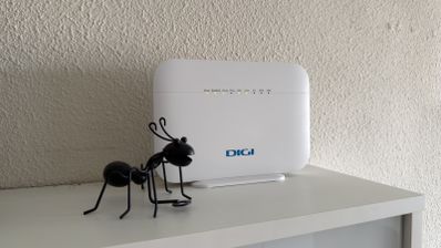 Router Wi-Fi moderno sobre una superficie de madera mostrando sus luces LED de estado encendidas en color verde y azul