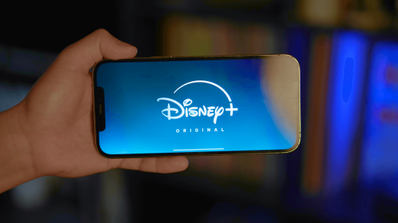 Sujetando un smartphone con el logo de Disney+
