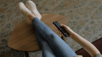 Chica usando el mando mientras ve una película