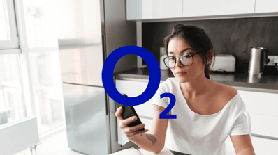 Usuario preocupado revisando una factura de O2 en su ordenador portátil mientras consulta su teléfono móvil, ilustrando un problema de facturación inesperada tras una portabilidad
