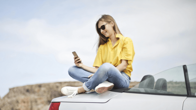 Una chica contenta mirando su teléfono