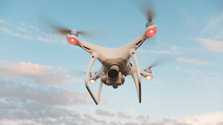 Dron de vigilancia tipo militar volando sobre un terreno montañoso, ilustrando la capacidad de observación de estas aeronaves