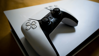 Imagen de un mando de PS5 superpuesto sobre la consola