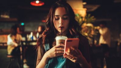 Chica bebiendo café con el móvil