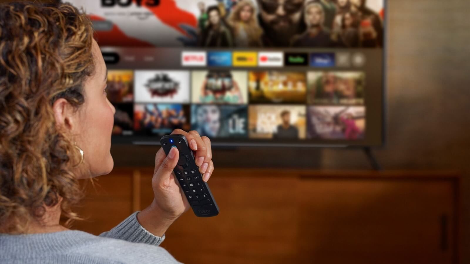 Una mujer usando el mando de los Fire TV