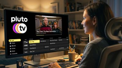 Mujer viendo canales Pluto TV en monitor PC