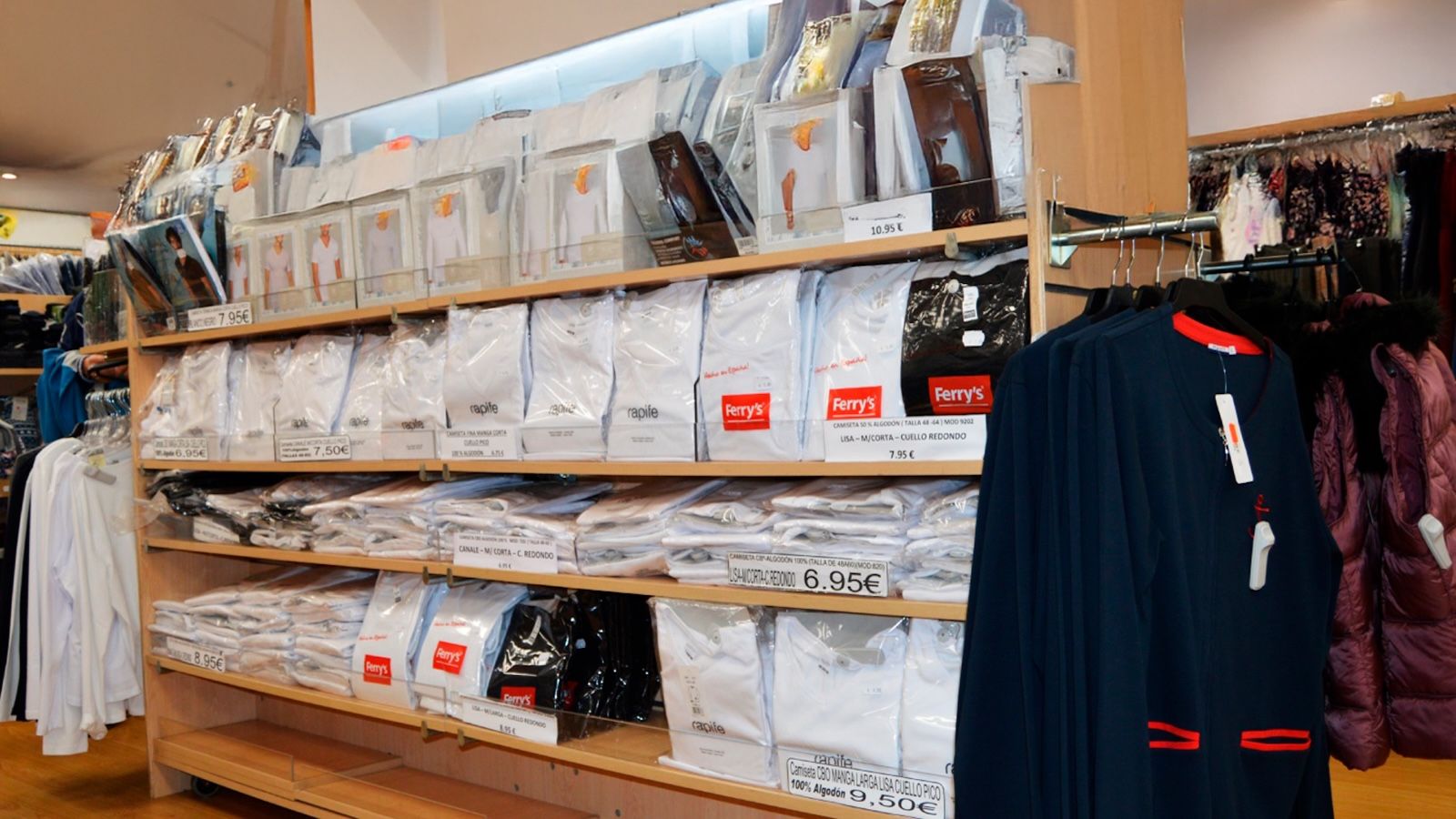 Fachada emblemática de una tienda Cadena Q en una calle de Madrid, con maniquíes mostrando ropa casual en el escaparate días antes de su cierre definitivo