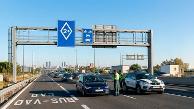 Señal de tráfico rectangular azul con rombo blanco en su interior, identificativa de carril BUS-VAO en carretera española, según normativa DGT 2026