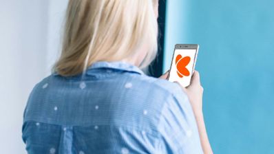 Una mujer usando el móvil con logo de Euskaltel