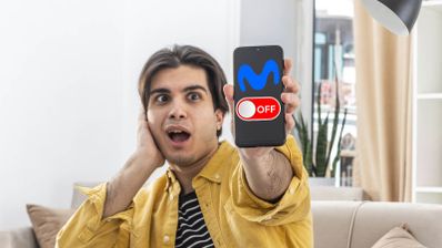 Hombre joven con expresión de sorpresa sujetando un smartphone que muestra el logotipo de Movistar y un interruptor en posición de apagado.