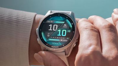 Primer plano de un reloj inteligente Garmin Fenix 8 en la muñeca con pantalla digital avanzada en tonos verdes y negros.